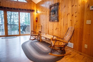 Ein Holzinnenraum mit Schaukelstuhl, Bank und Kamin.