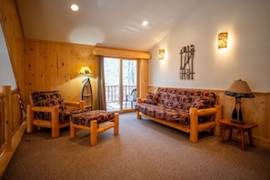 A wooden interior with a sofa, chairs, and a lamp. - Rustic luxury at its finest: The Bent Paddle (Babbitt)