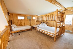A wooden cabin with bunk beds and a single bed, carpeted floors, and a window. - Ultimate Group Getaway. Luxury Private Lodge Sleeps 15. CB 15. (Babbitt)