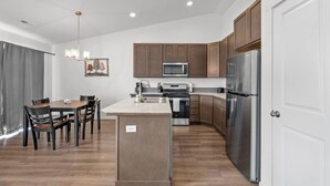 Una cucina moderna con mobili in legno, elettrodomestici in acciaio inossidabile e un'isola centrale.