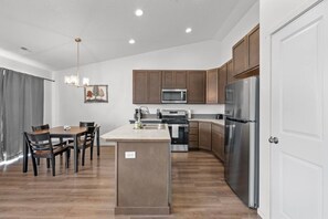 A modern kitchen with wooden cabinets, stainless steel appliances, and a central island.