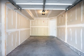 Eine Garage mit unbehandelten Wänden, einem Betonboden und einer Deckenleuchte.