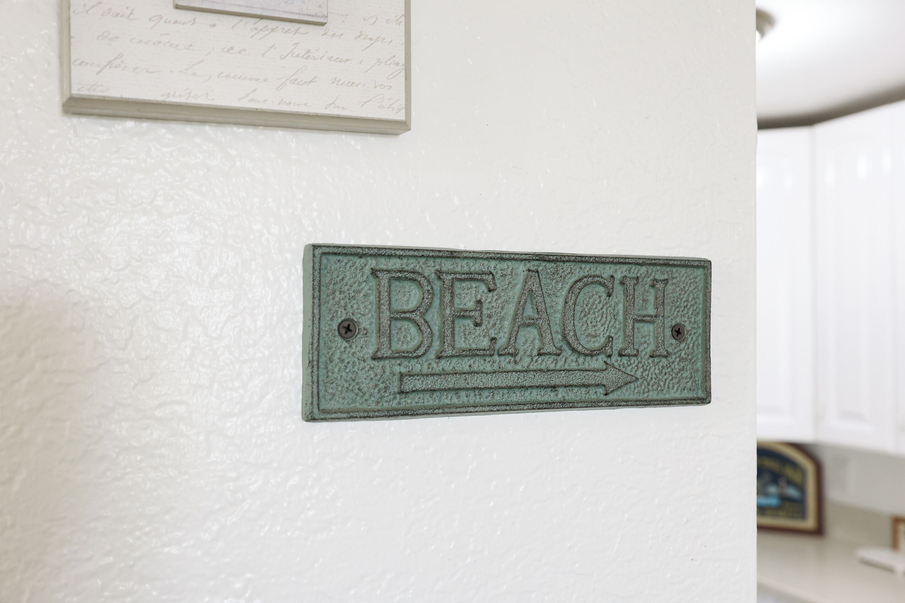 Een bord aan de muur met de tekst 'BEACH' en een pijl naar rechts.