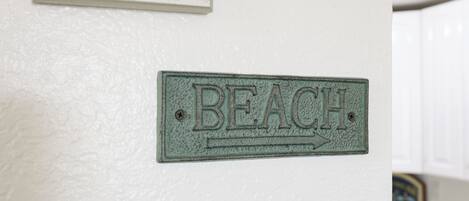 Een bord aan de muur met de tekst 'BEACH' en een pijl naar rechts.
