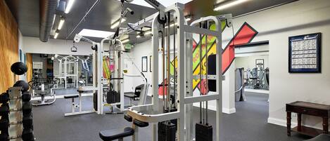 A gym with various exercise equipment, including weight machines and dumbbells.