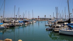 A marina with multiple boats docked, calm water, and a clear sky. - Come Stay at G208 Secluded One Bedroom Unit Near the Ocean (Oceanside)