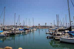 A marina with multiple boats docked, calm water, and a clear sky. - Come Stay at G208 Secluded One Bedroom Unit Near the Ocean (Oceanside)