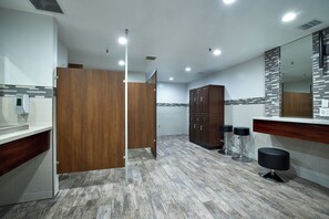 A modern bathroom with a wooden partition, a large mirror, and a bar stool. - Come Stay at G208 Secluded One Bedroom Unit Near the Ocean (Oceanside)