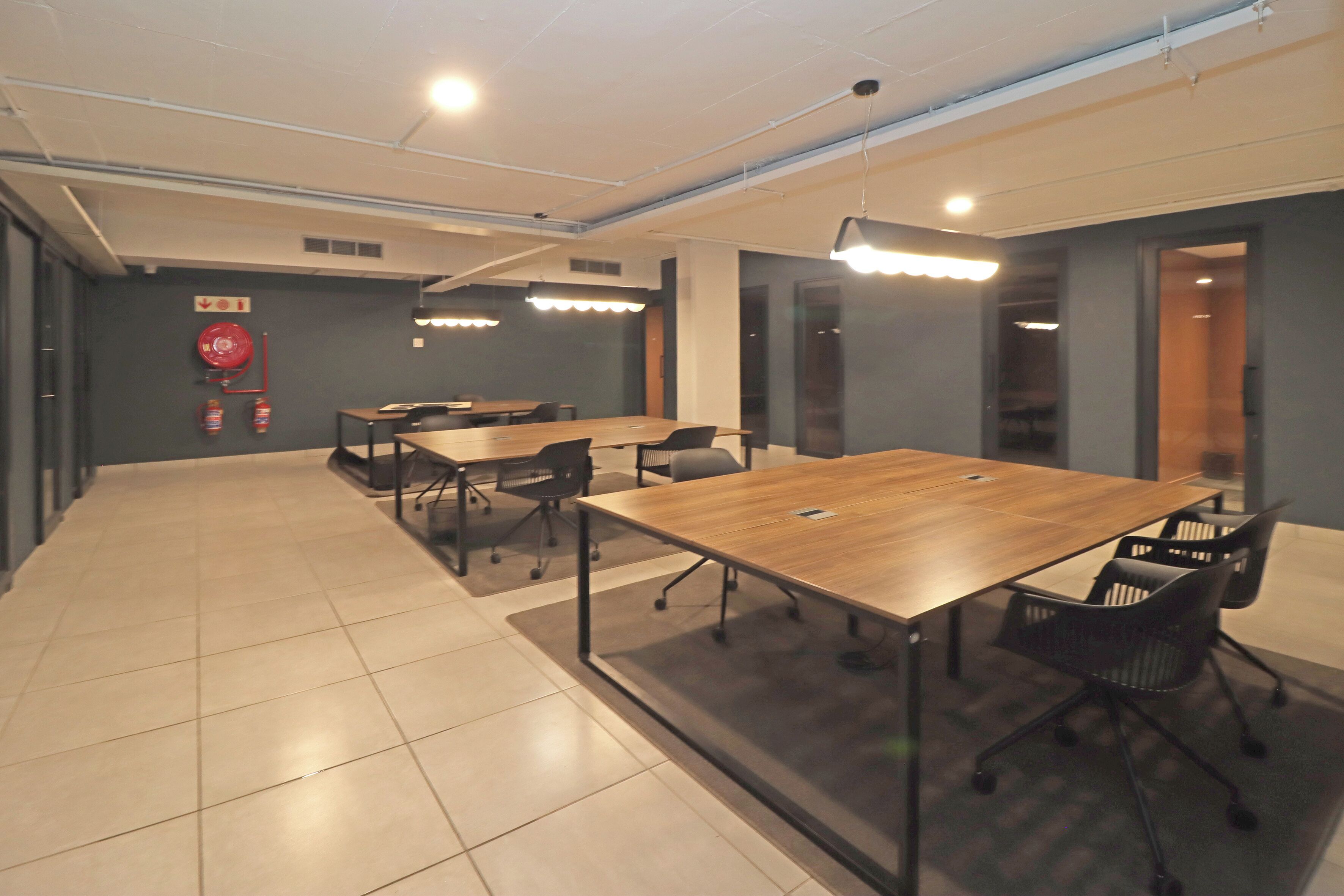 A conference room with a long table, chairs, and overhead lighting.