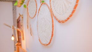 Eine Wand mit dekorativen Webkunstwerken und einem hölzernen Geländer.