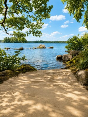A sandy path leading to a lake with rocks and greenery on both sides. - Sebago Lake Estate, 300’ Frontage, Inside the State Park, Private Dock & Kayaks (Casco)