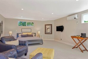 A bedroom with a bed, a sofa, a coffee table, a TV, and an air conditioning unit. - Sonoma Highland Serene Retreat (Sonoma)