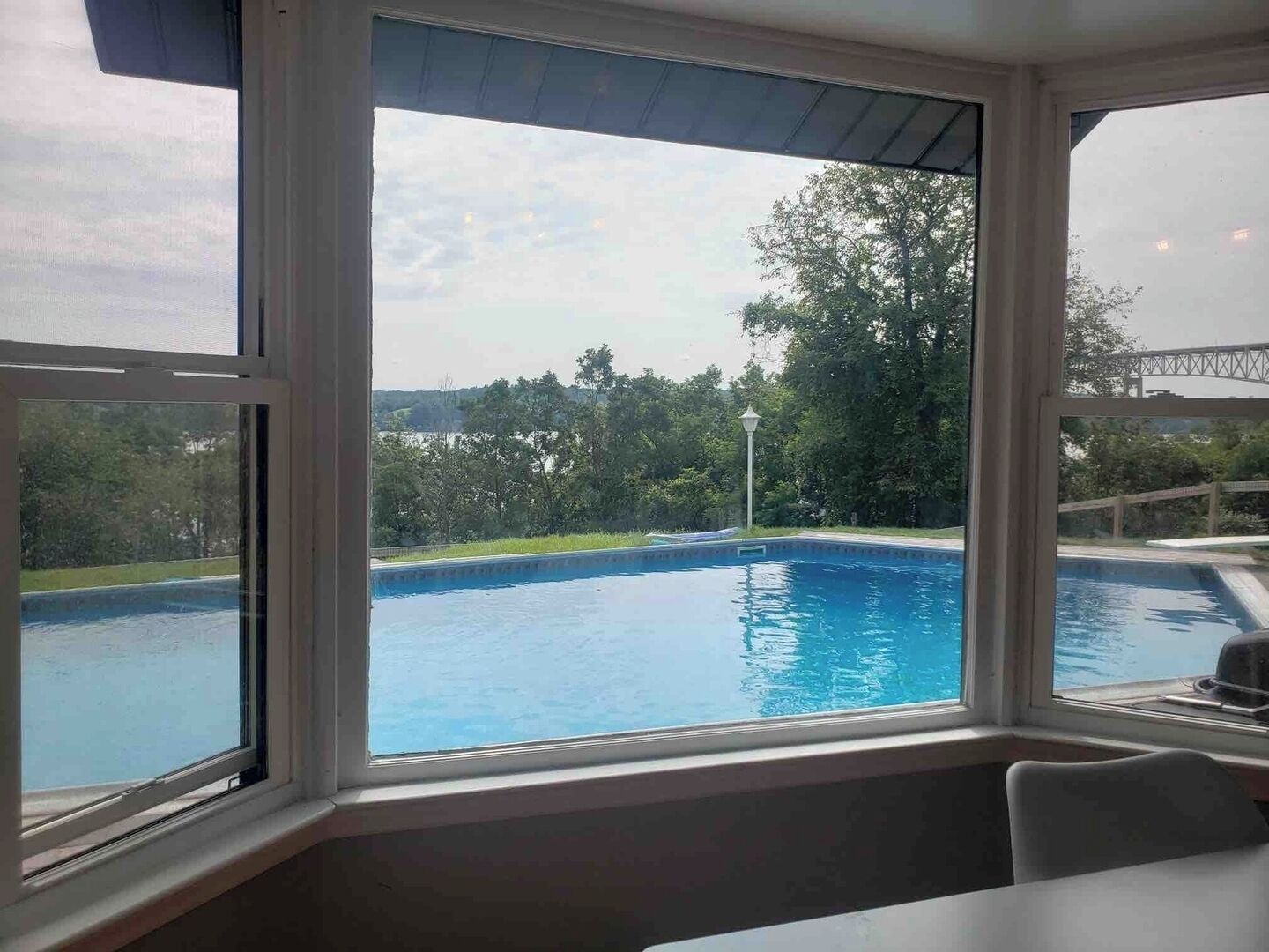 A room with a large window overlooking a swimming pool.