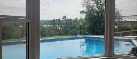 A room with a large window overlooking a swimming pool.