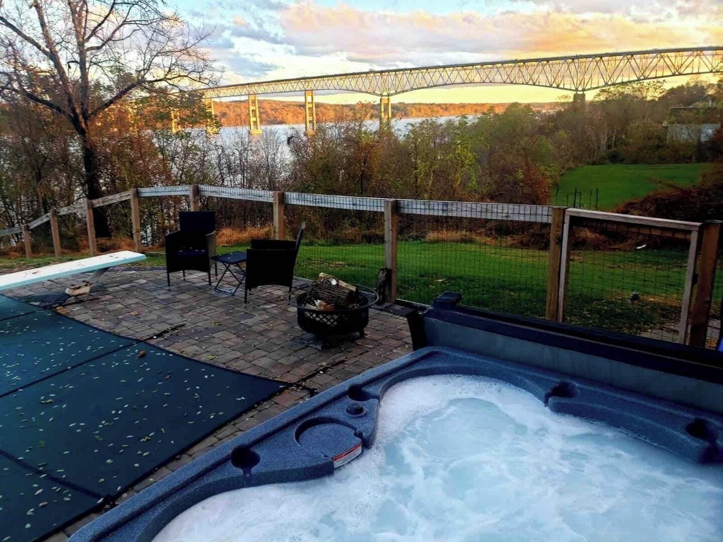 Ein Bereich mit Whirlpool und Blick auf eine Brücke sowie einen Rasen.