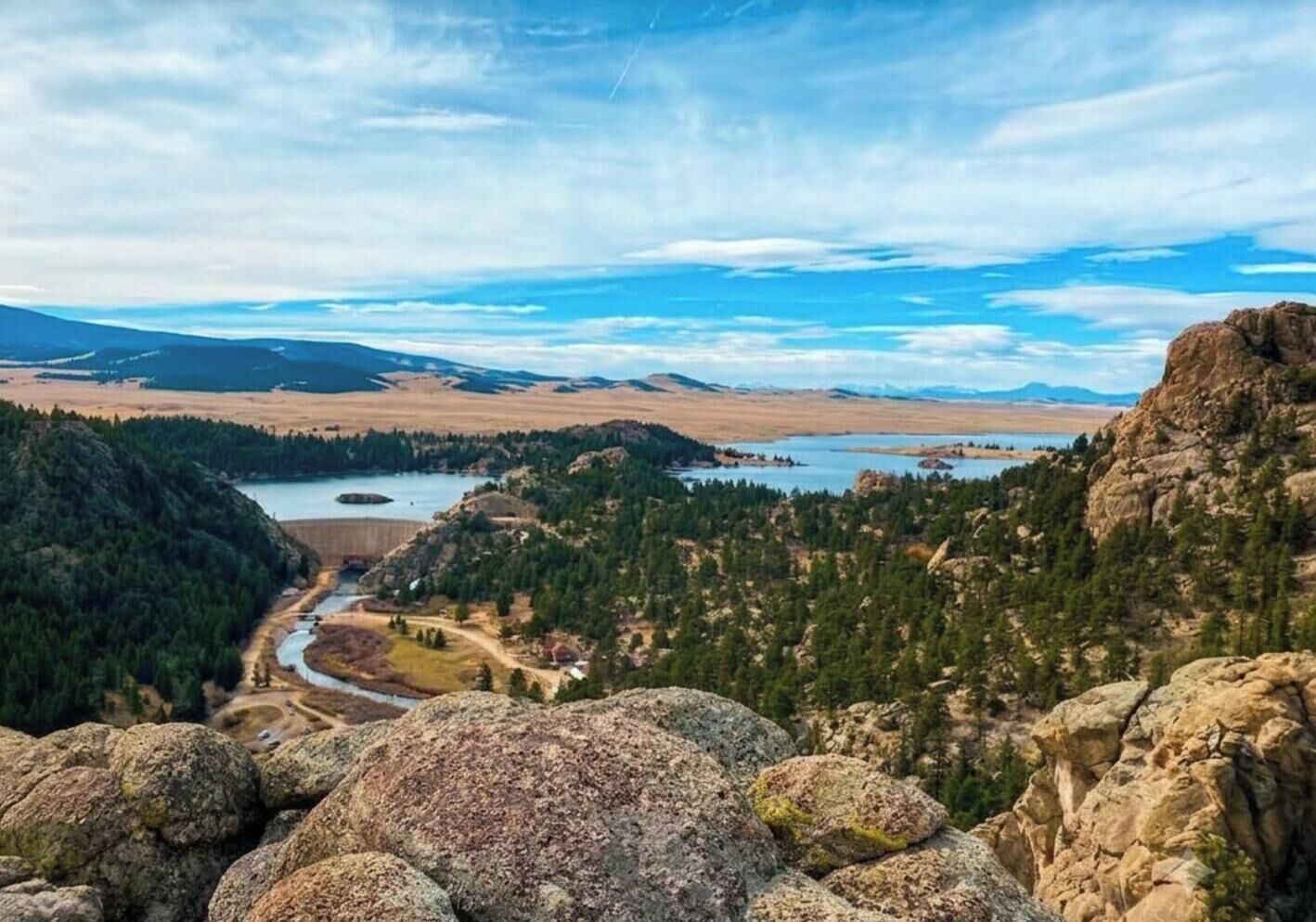 Paisaje montañoso con un río, zonas boscosas y afloramientos rocosos.
