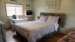 Ein Schlafzimmer mit Bett, Schreibtisch, Stuhl, Lampe und Fenster.