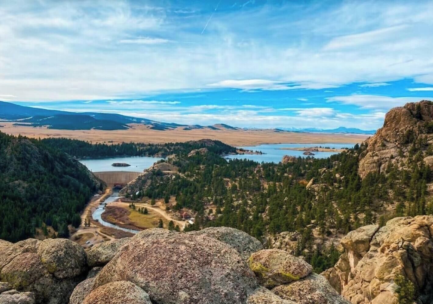 Paisaje montañoso con un río, zonas boscosas y afloramientos rocosos.