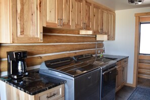 A kitchen with wooden cabinets, a stainless steel stove, and a coffee maker.