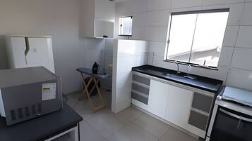 Una cocina moderna con armarios blancos, encimera negra y ventana que proporciona luz natural.