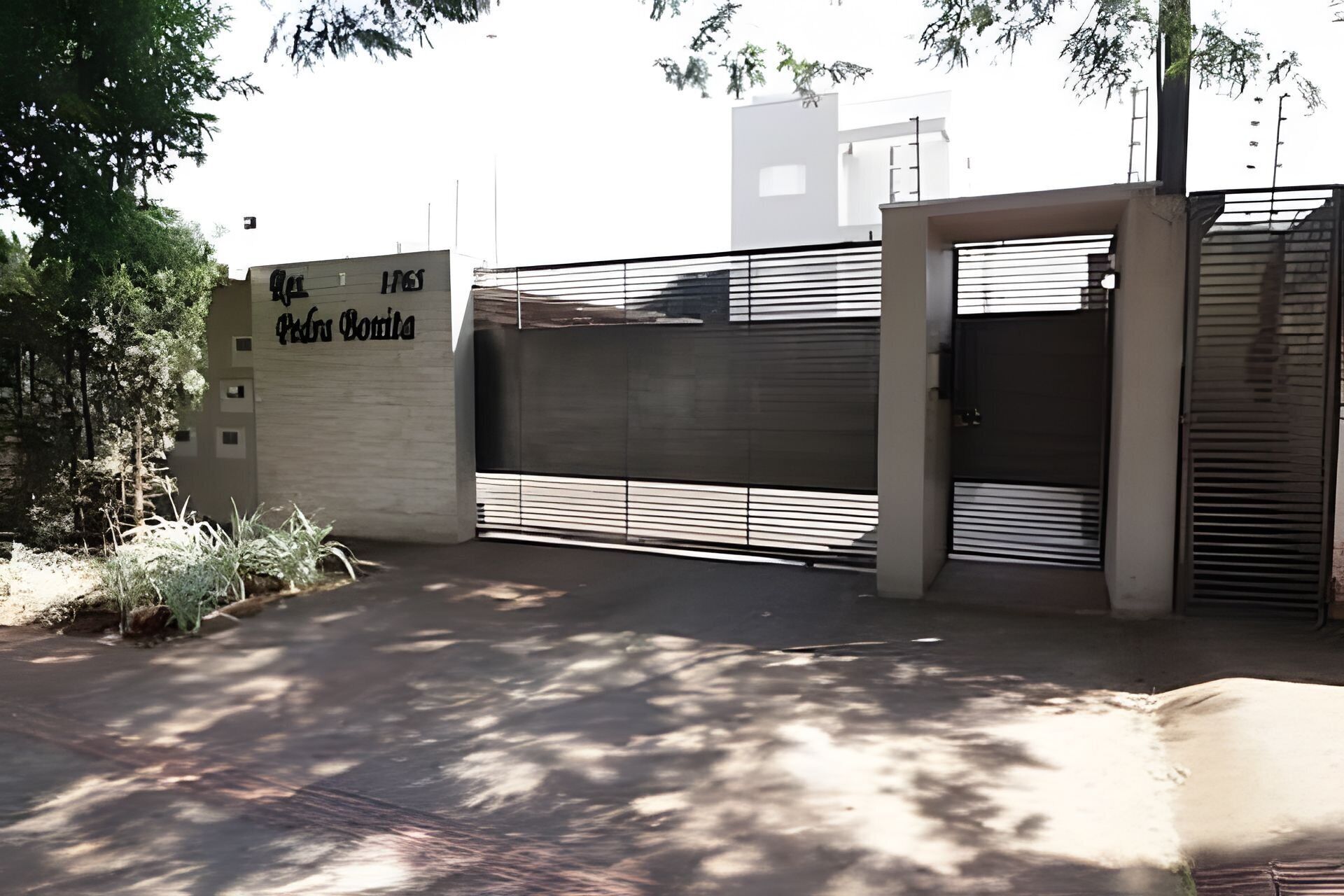 A gated entrance with a sign reading 'Hotel Botella.'