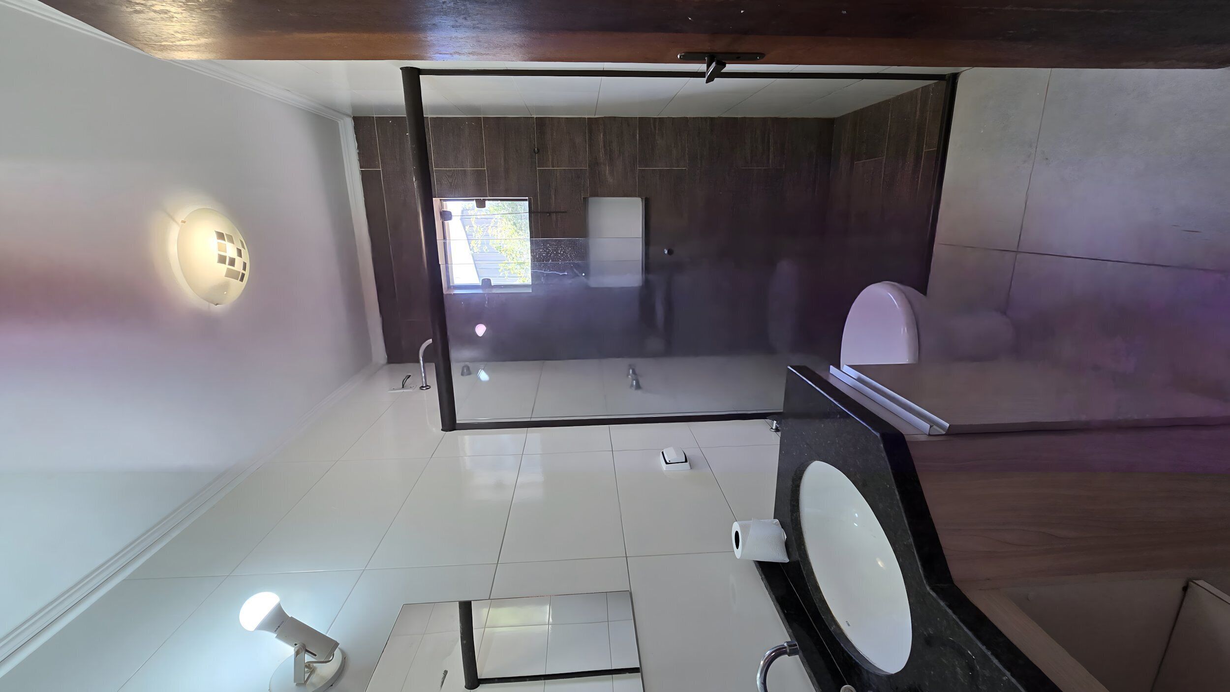 Un baño moderno con un espejo grande, un inodoro y un bidé.