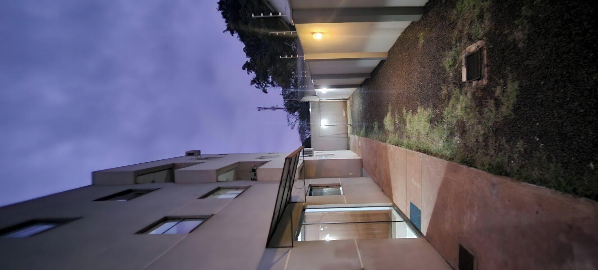 A modern building with a glass staircase leading to an upper level.