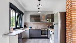 A modern kitchen with a built-in oven, a washing machine, and a refrigerator.