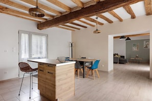 Una cocina moderna con una isla de madera, taburetes de bar e iluminación colgante.
