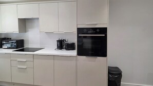 A modern kitchen with a built-in oven, a microwave, and a kettle. - Luxury retreat In the heart of St Neots, free parking and close to town centre (St. Neots)