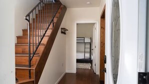 A staircase with wooden steps and metal railings leading to a room with a bunk bed. - Wrap-around deck, cozy home, gateway to the Canyon. (Williams)