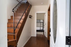 A staircase with wooden steps and metal railings leading to a room with a bunk bed. - Wrap-around deck, cozy home, gateway to the Canyon. (Williams)