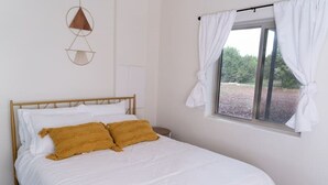 A bedroom with a bed, white curtains, and a window with a view. - Wrap-around deck, cozy home, gateway to the Canyon. (Williams)