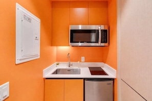 A compact kitchen with a stainless steel microwave, a sink, and a dishwasher. - 003 Cook - Loft in the Heart of Old Quebec (Québec)