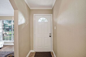 A hallway with a white door, beige walls, and a window with blinds. - Family Getaway: 4BR, BBQ Yard, Steps to Park (La Porte)