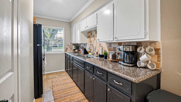 A kitchen with dark cabinets, a granite countertop, a coffee maker, and a window with blinds. - Family Getaway: 4BR, BBQ Yard, Steps to Park (La Porte)