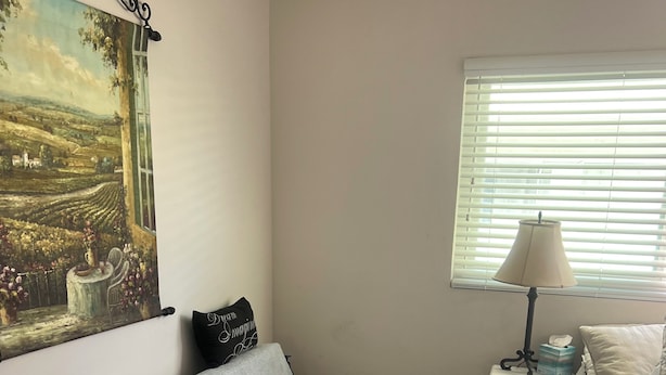 A bedroom with a bed, a nightstand, a lamp, a painting, and a window with blinds. - Fabulous 2-bedroom apartment in sunny San Clemente perfect for relaxing (San Clemente)