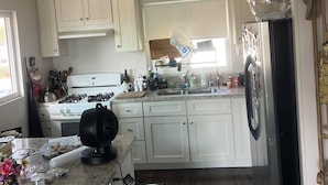 A kitchen with white cabinets, a stainless steel refrigerator, and a gas stove. - Fabulous 2-bedroom apartment in sunny San Clemente perfect for relaxing (San Clemente)