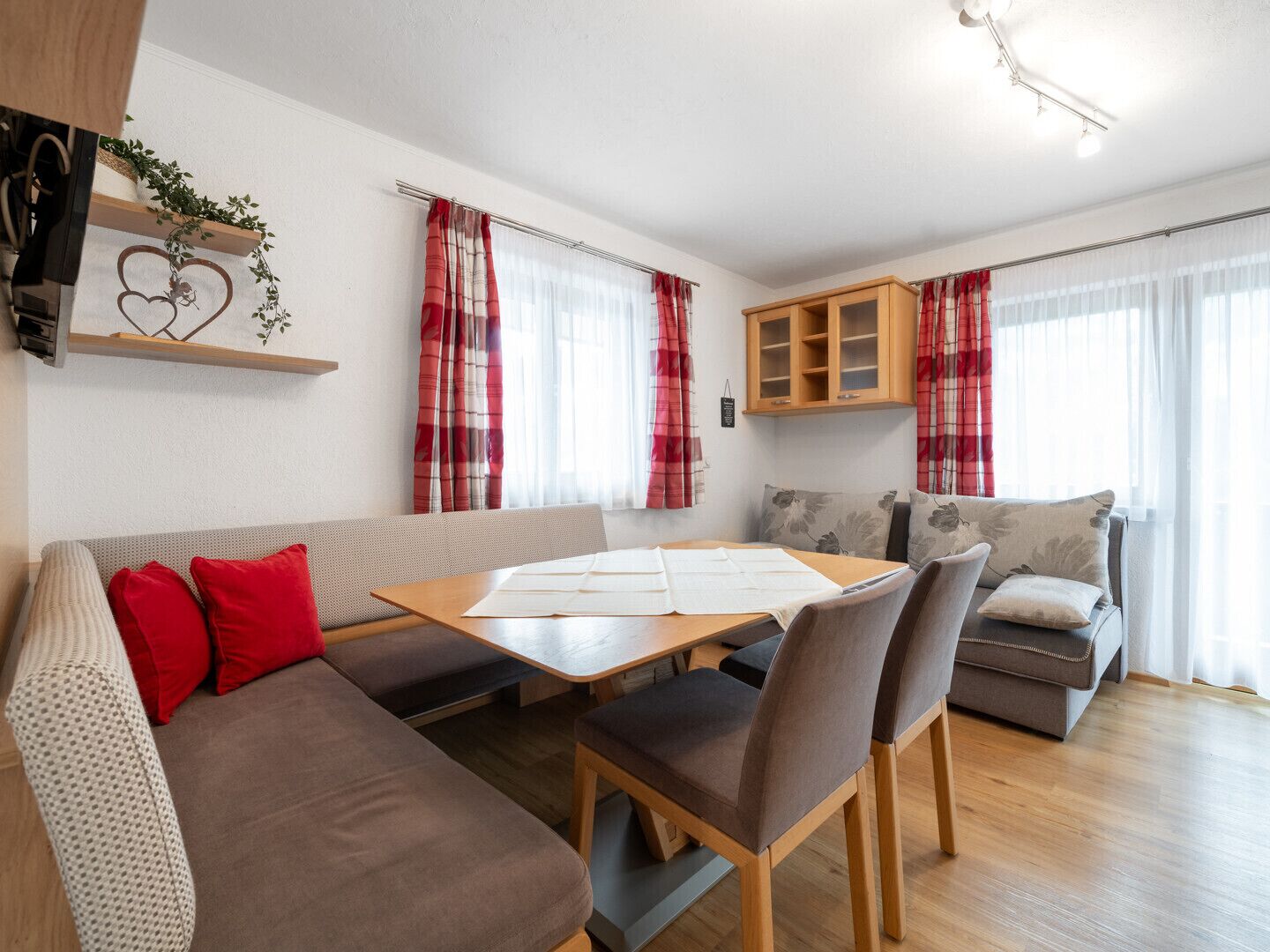 Ein modernes Wohnzimmer mit Sofa, Esstisch und Küchenzeile.