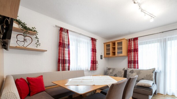 Una sala de estar moderna con un sofá, una mesa de comedor y una zona de cocina.