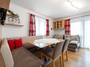 Ein modernes Wohnzimmer mit Sofa, Esstisch und Küchenzeile.
