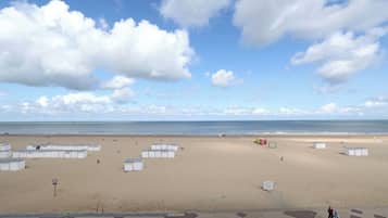 Una playa con cabañas blancas y cielo despejado.