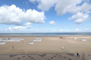 A beach with white beach huts and a clear sky. - Sea View Apartment in the Heart of Zoute (Knokke-Heist)