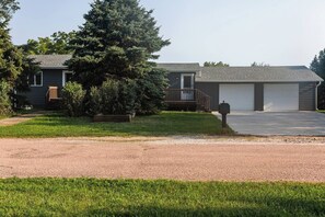 A residential property with a two-car garage, a covered porch, and a well-maintained lawn. - Whitmen & 5th in Spencer (Spencer)