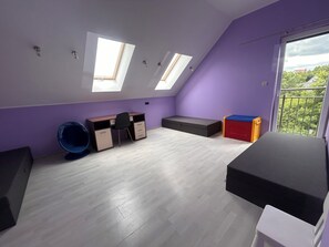A room with a sloped ceiling, skylights, a desk, a chair, a bed, and a window with a view. - A spacious house with a garden by the sea, close to the beach and the pier. (Mosty)