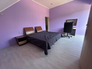 Une chambre à coucher avec un lit, une table de chevet, un bureau et une chaise.
