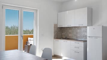 A modern kitchen with white cabinets, a built-in oven, and a sink.