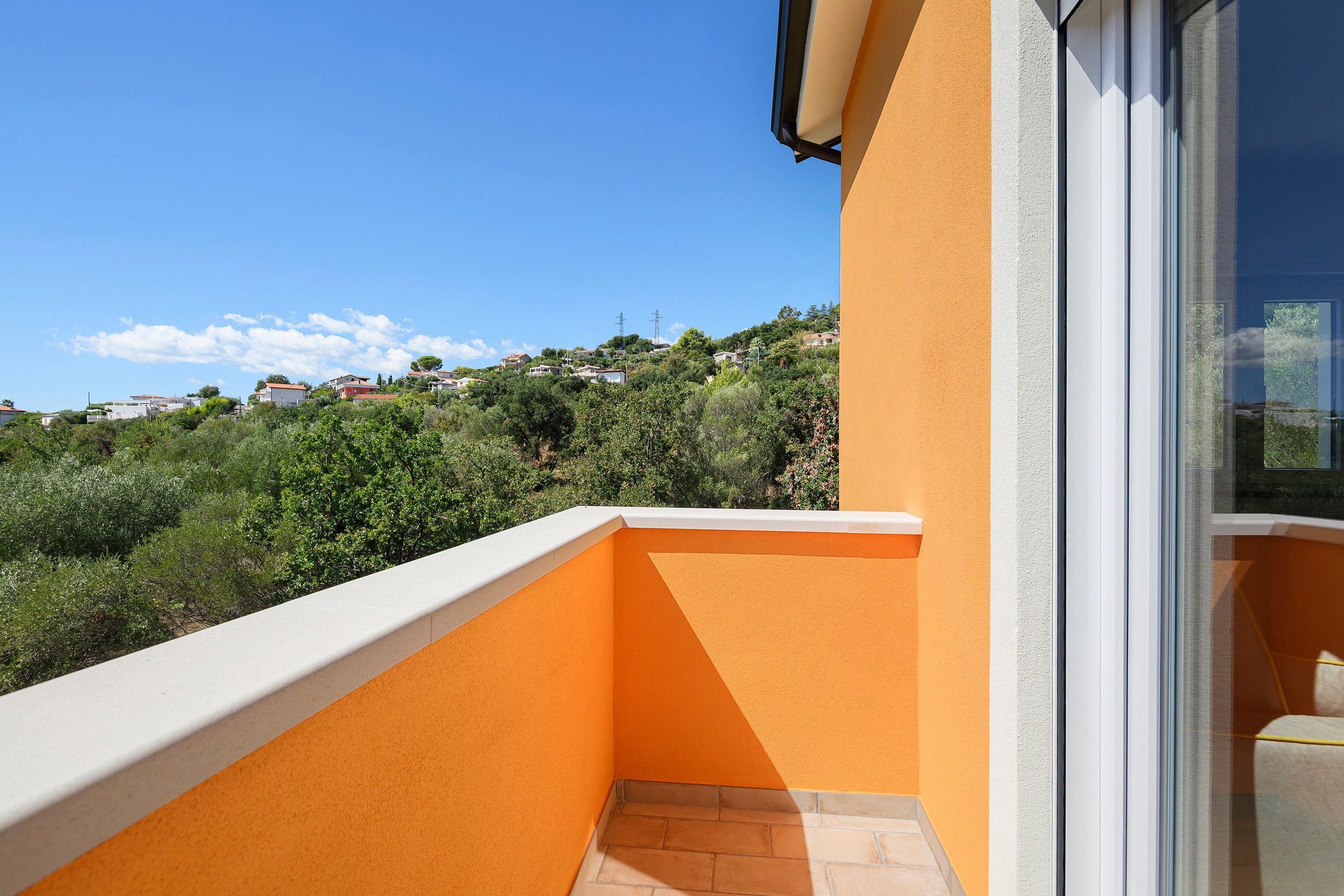 Un balcone con vista su una collina con case.