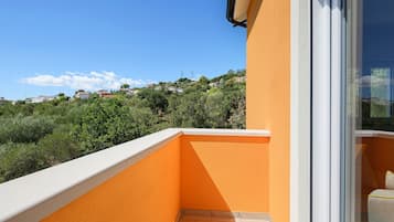 Un balcone con vista su una collina con case.