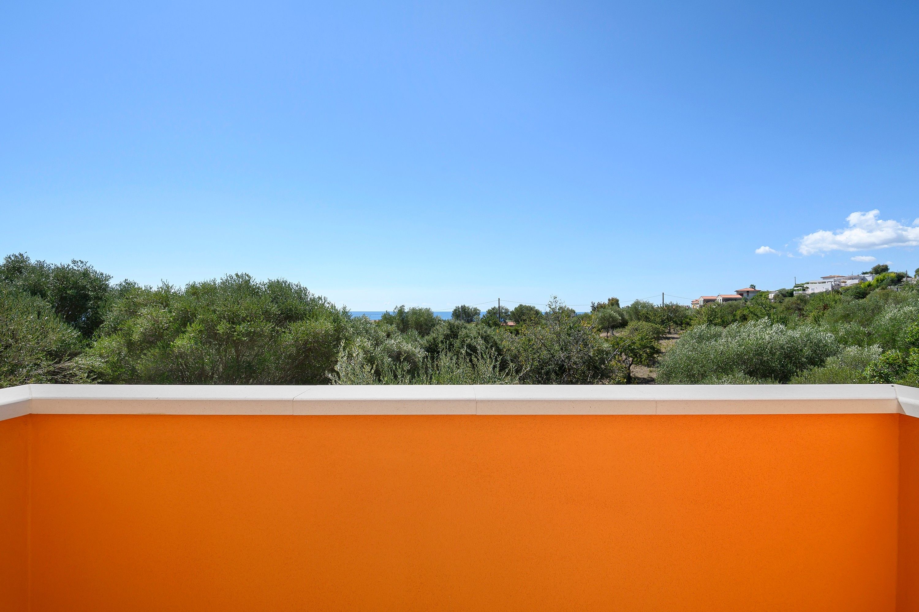 Une vue d’un bâtiment à la façade orange, avec un ciel bleu clair en arrière-plan.